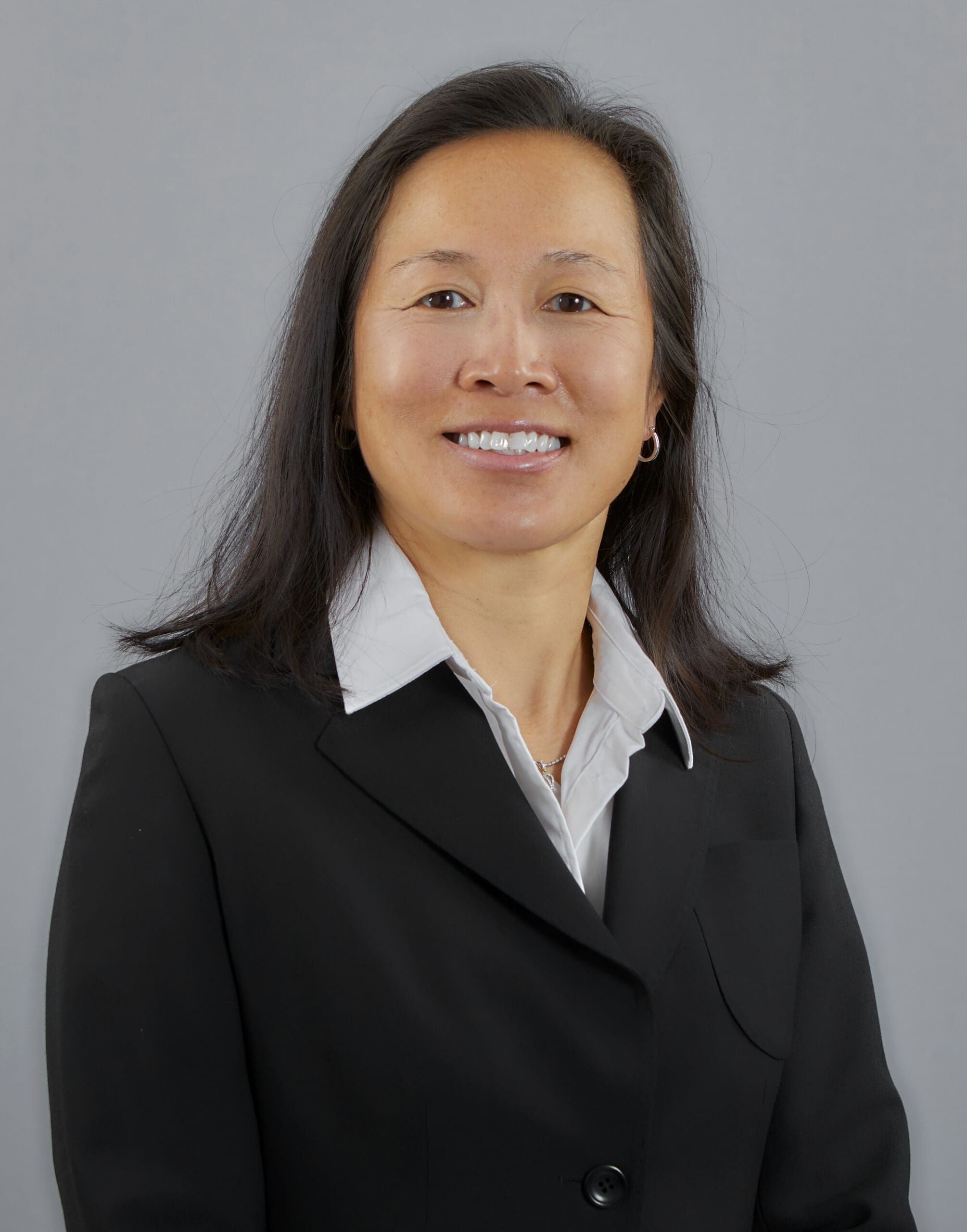 A photo of Dr. Denise Leong-Yokota, a prosthodontist, smiling warmly.