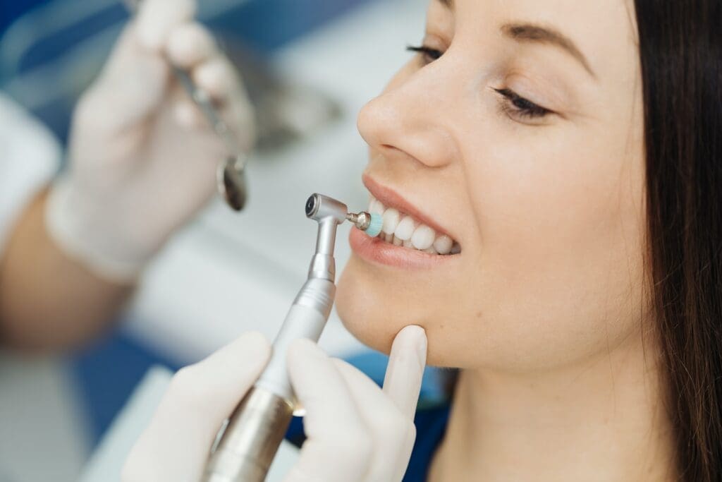 A person smiling after a dental cleaning, highlighting the importance of regular cleanings.