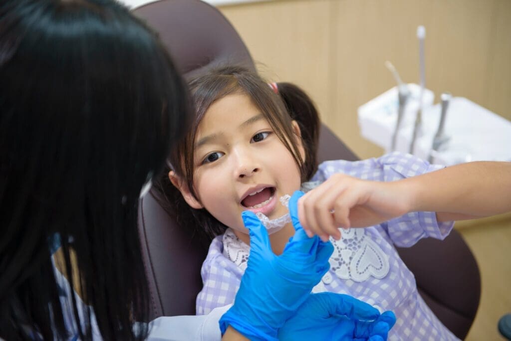 Close-up of a child's bright smile showcasing clean, white teeth and healthy gums.