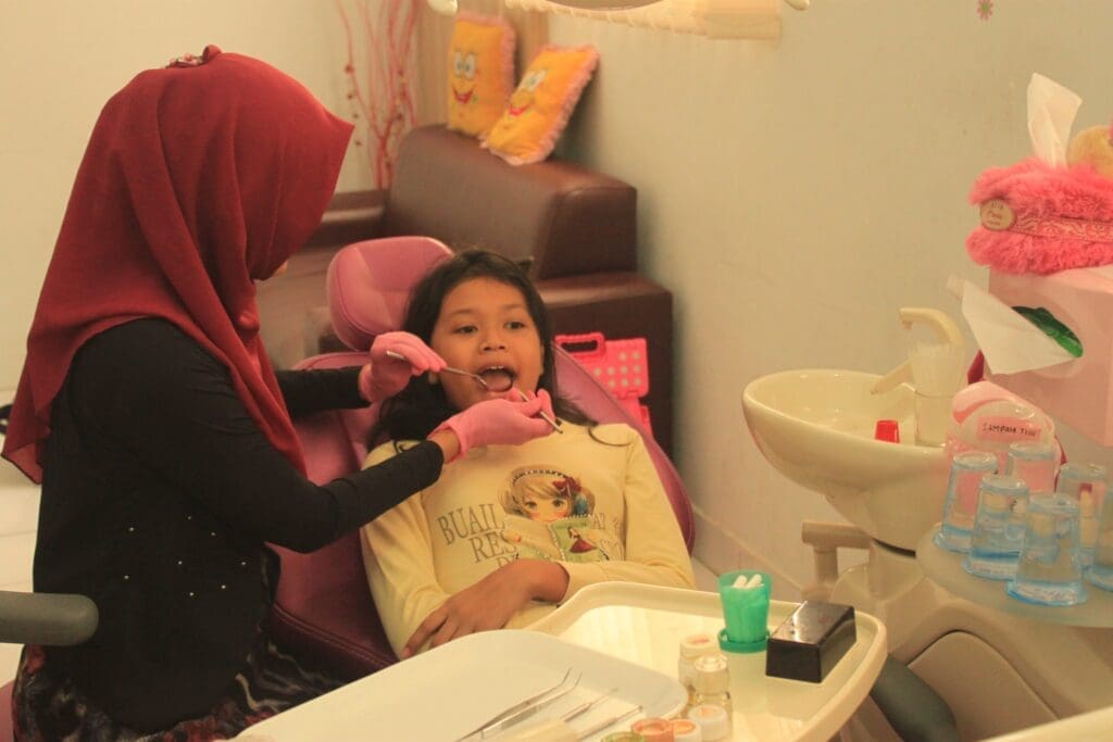 A child smiling during their first dental visit at Waban Dental Group in Newton, MA.