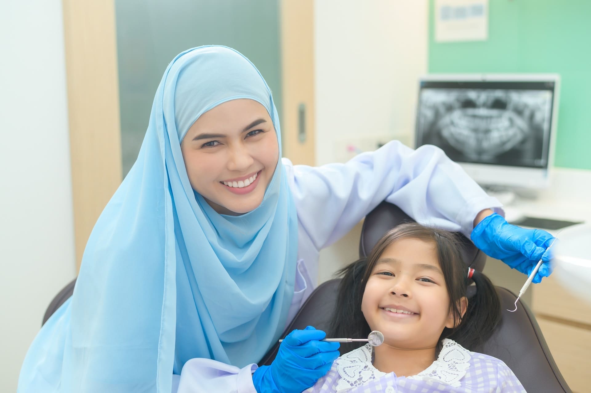 A parent discussing pediatric dentistry FAQs with a dentist at Waban Dental Group in Newton, MA.