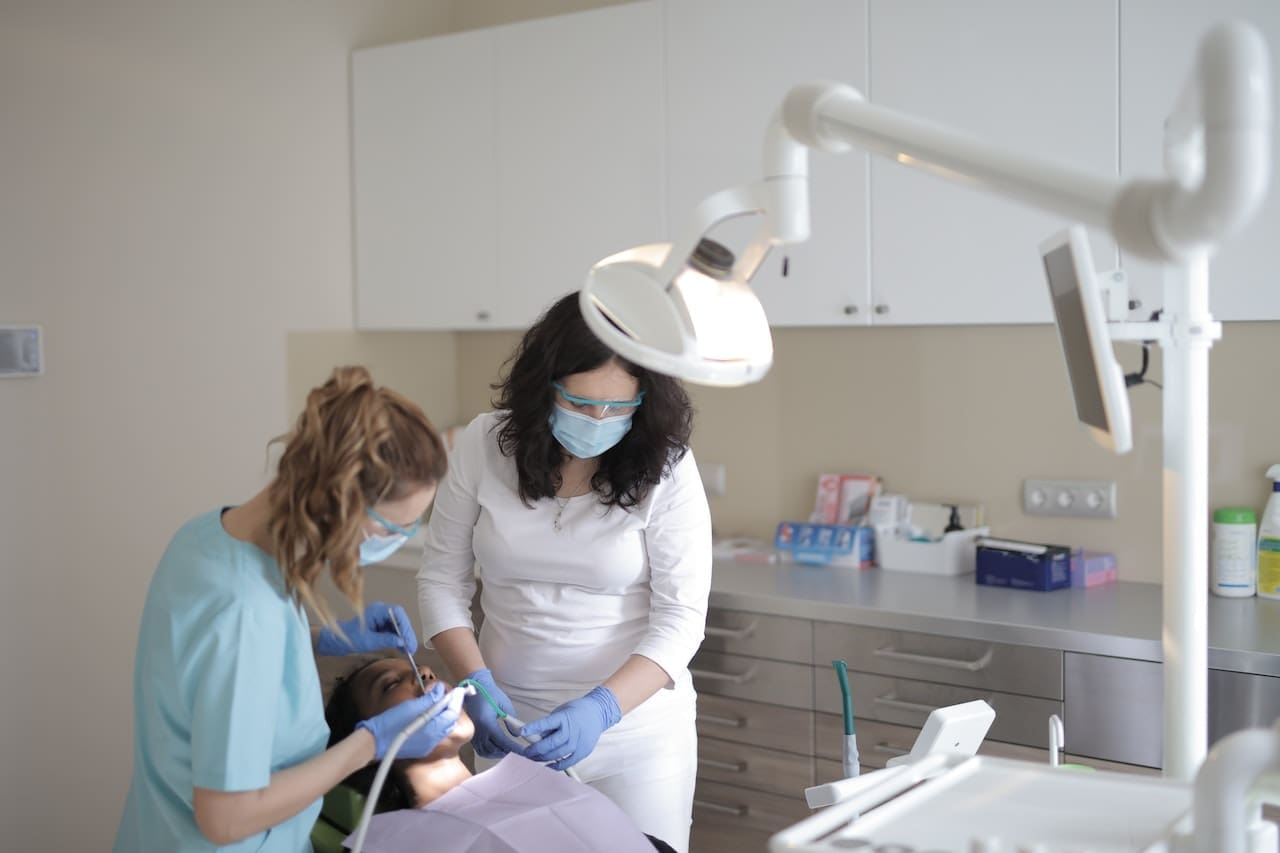 An adult looking at their reflection and smiling, seeing the results of their orthodontic treatment for the first time.