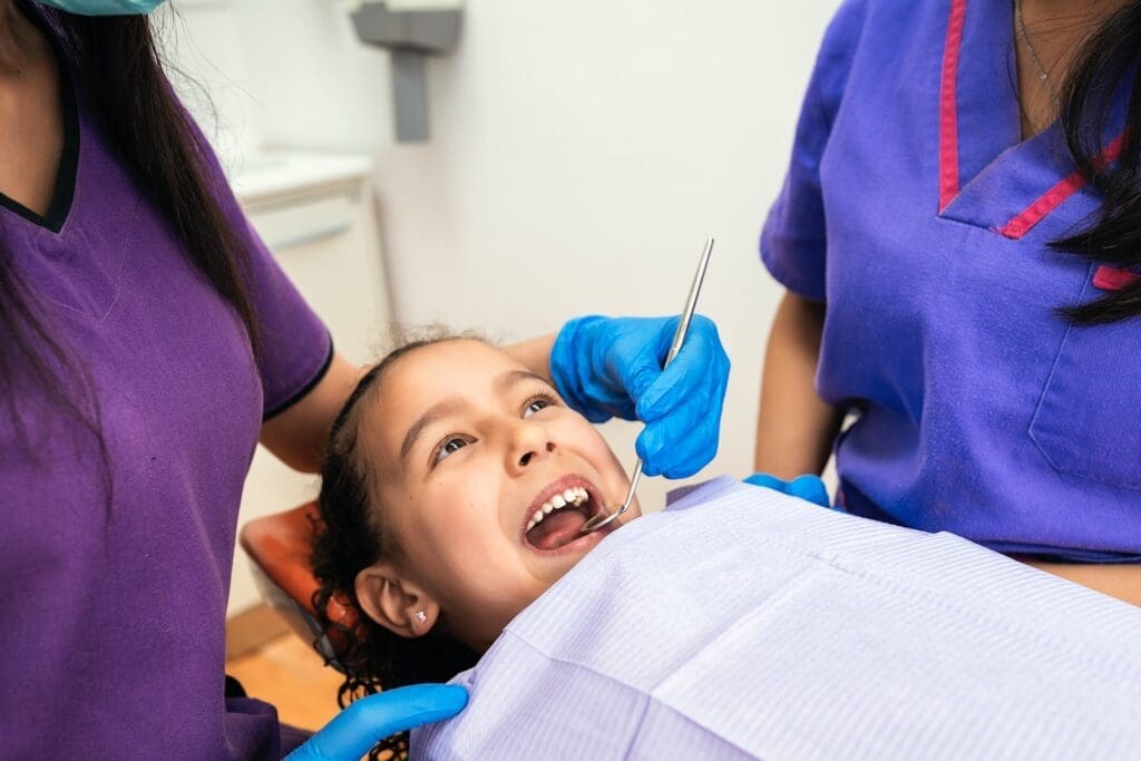 A child being comforted by the best pediatric dentist in Newton, MA, during a dental emergency visit.