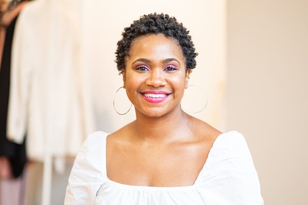 A close-up photo of a person smiling confidently, showing off their dental implants.