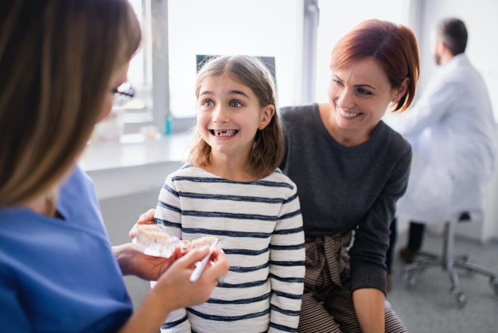 Image depicting a dentist applying dental sealants to a child's teeth at Waban Dental Group, Newton, MA, for enhanced tooth protection.