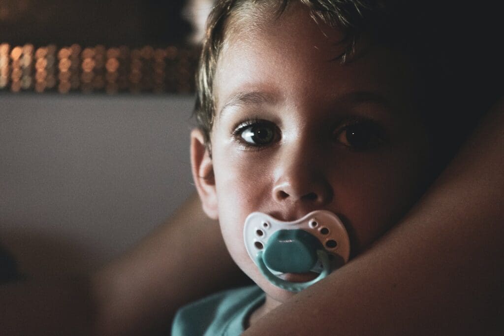 Illustration showing a parent helping their child overcome thumb-sucking and pacifier dependency, provided by Waban Dental Group in Newton, MA.