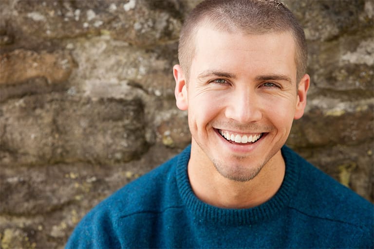 A smiling man sitting outdoors