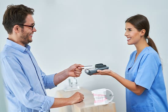 A patient paying for dental implant treatment