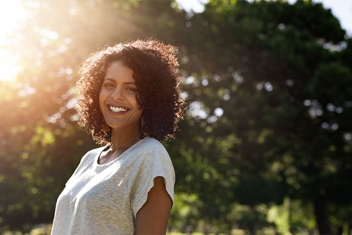 A woman smiling while standing outside