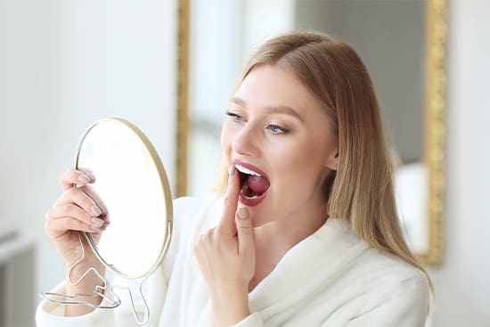 Patient in Newton checking their dental implants in the mirror
