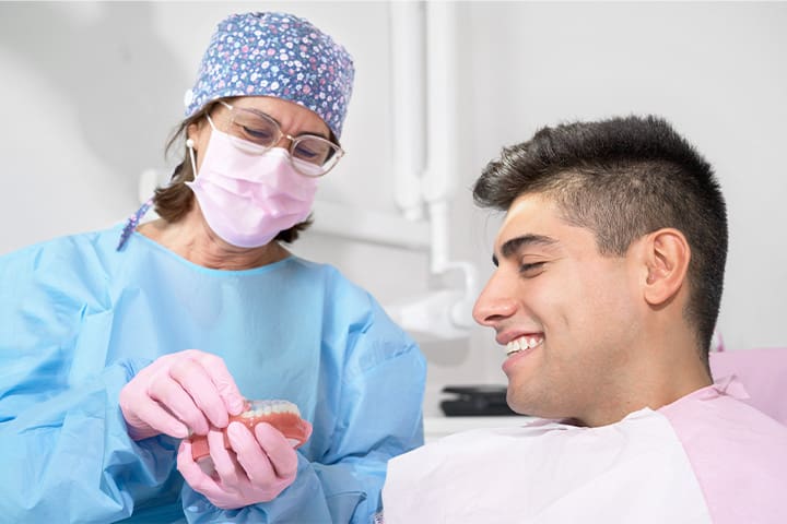 Patient in Newton talking to dentist after getting dental implants