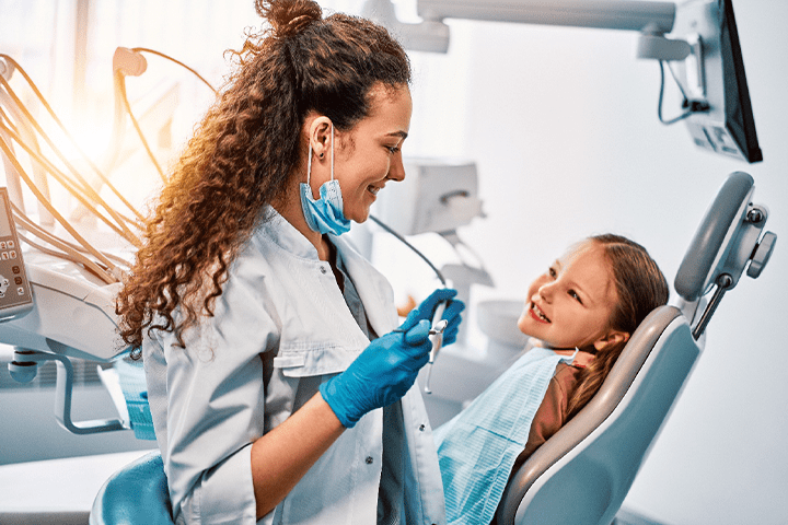 A pediatric dentist about to examine a child’s mouth