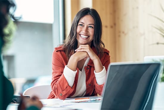 Woman smiling during meeting in office.