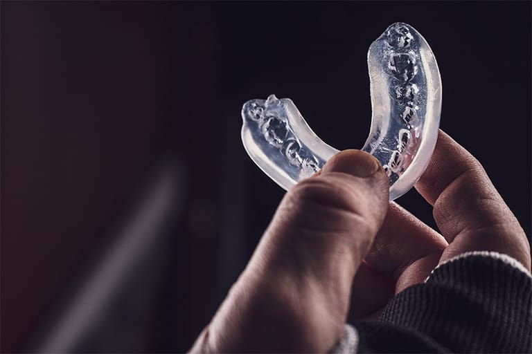 Person holding a mouthguard.