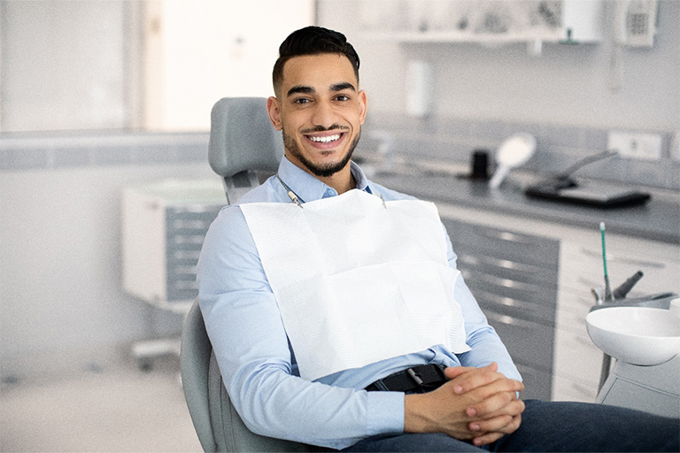 Patient smiling while sitting in treatment chair.