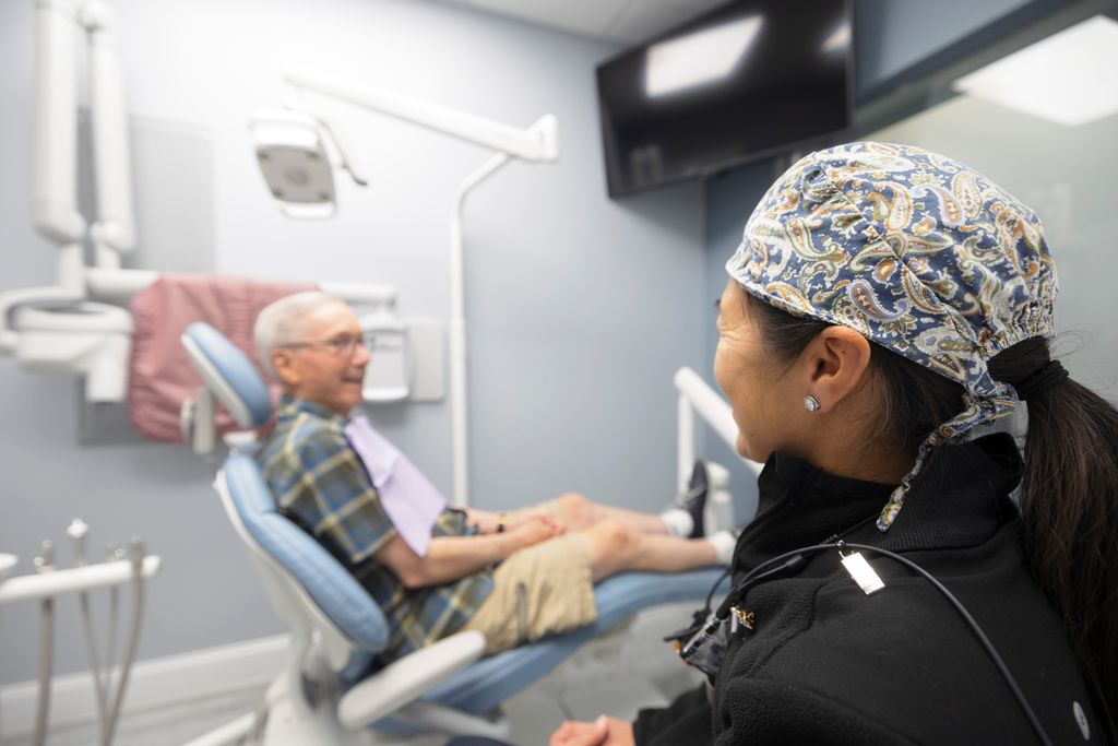 Dentist in Newton attending older patient.