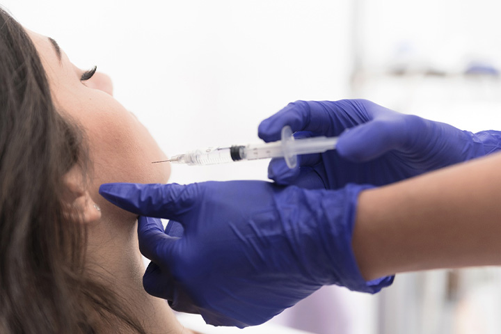Close-up of woman receiving BOTOX injection in jaw.