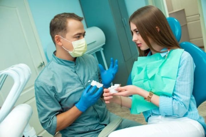 Patient Talking To Dentist Before Getting Dental Implants.