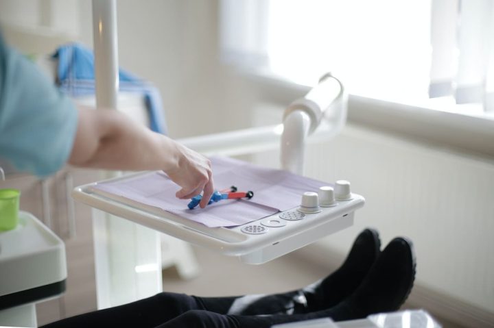 A concerned parent holding their child's hand during a dental emergency visit, seeking guidance from the best pediatric dentist in Newton, MA.