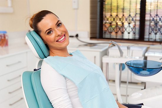 Smiling woman sitting back in dental chair.