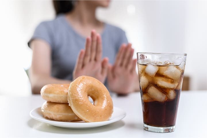Woman saying no to donuts and soda